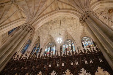 Kubbeli tavan manzarası ve gotik bir katedralin içindeki canlı vitray pencereler. Karmaşık taş sütunlar ve süslü ahşap korkuluklar bu kutsal yerin güzelliğini arttırıyor..