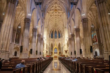 New York City, New York, ABD - 07.31.2024: Büyük Gotik katedralinin geniş açılı bir görüntüsü altın sunağa uzanan sıraları gösteriyor. Mimari, uzun sütunlar, kemerler ve boyalı cam pencerelerle tanımlanır..