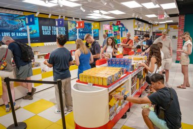 New York City, New York, ABD - 07.31.2024: Her yaştan insan yoğun bir oyuncakçıdan renkli inşaat setleri satın alır. Mağaza popüler oyuncaklar, parlak ekranlar ve etkileşimli alışveriş bölgeleriyle dolu..