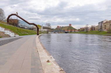 Gediminas Tower visible In the distance, historical symbol of Vilnius and Lithuania and river Neris promenade.