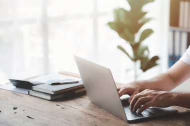 Laptop klavyesinde yazan kişi, dizüstü bilgisayarda çalışan iş adamı, iş arkadaşlarına mesaj yazıyor ve toplantıyı özetlemek için mali bilgi tablosu hazırlıyor..