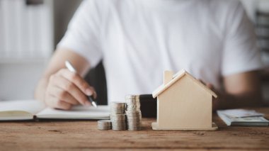 Bir kişi kişisel bir hesap yapıyor, tasarruf ve yatırım için etkin mali planlama için maaş, gelir ve harcamaları hesaplıyor. Kişisel gelir ve giderlerin hesaplanması kavramı.