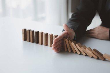 Tahta blokları arka arkaya tutan bir iş adamının yakın plan çekimi, ahşap bloklar iş risk yönetimiyle karşılaştırılır. Risk yönetimi kavramı. Boşluğu kopyala.