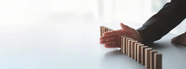 Stock image A close-up shot of a businessman holding the wooden blocks in a row, the wood blocks compare to the business risk management. The concept of risk management. copy space.