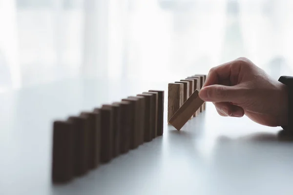 stock image A close-up shot of a businessman holding the wooden blocks in a row, the wood blocks compare to the business risk management. The concept of risk management. copy space.