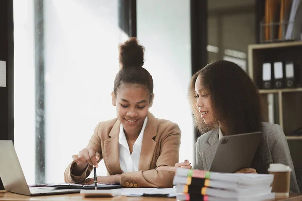 stock image Two American women are working together in the office of a startup company. They are having a brainstorming and planning meeting in a joint department, women leading the way. Concept of women's work.