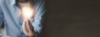 Person holding glowing lamp, Creative new idea. Innovation, brainstorming, strategizing to make the business grow and be profitable. Concept execution, strategy planning and profit management.