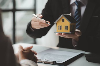 The salesperson of the housing estate in the project is preparing and verifying the contract of sale for the customer who will enter the contract. Concept of selling housing estates and real estate.
