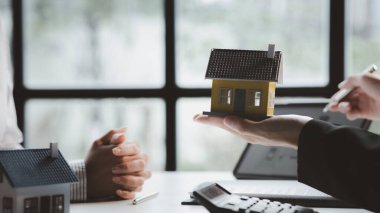 The salesperson of the housing estate in the project is preparing and verifying the contract of sale for the customer who will enter the contract. Concept of selling housing estates and real estate.