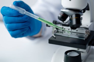 Laboratuvar asistanı, tıp bilimcisi, kimya araştırmacısı kan örneğinde cam bir tüp tutuyor, kimyasal bir deney yapıyor ve hastanın kan örneğini inceliyor. Tıp ve araştırma konsepti.