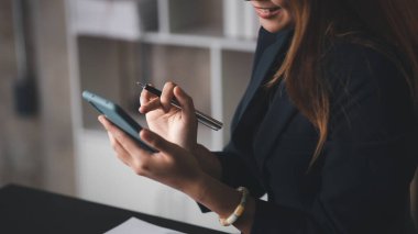 İşe ara verdiğinde cep telefonuyla oynayan güzel bir Asyalı kadın. Yeni başlayan bir şirketin pazarlama müdürü, kadın lider, yönetici ve CEO 'su. Kadın Liderlik Konsepti.