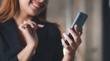 İşe ara verdiğinde cep telefonuyla oynayan güzel bir Asyalı kadın. Yeni başlayan bir şirketin pazarlama müdürü, kadın lider, yönetici ve CEO 'su. Kadın Liderlik Konsepti.