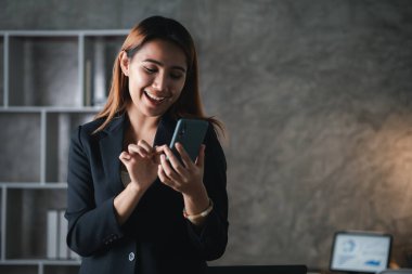 İşe ara verdiğinde cep telefonuyla oynayan güzel bir Asyalı kadın. Yeni başlayan bir şirketin pazarlama müdürü, kadın lider, yönetici ve CEO 'su. Kadın Liderlik Konsepti.