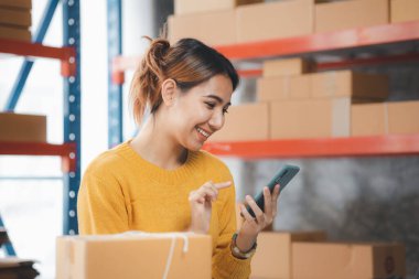 Online store salesperson is writing a customer's shipping address on parcel box before sending it to private carrier for delivery to customer. The idea of opening an online store and packing products.