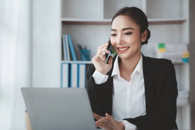 Telefonda konuşan Asyalı bir kadın, bir girişim şirketinde satış elemanı, ürün ve promosyon satmak için müşterileri arıyor. Telefon kanalları aracılığıyla ürün satma kavramı.