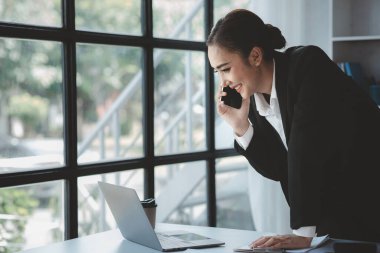 Telefonda konuşan Asyalı bir kadın, bir girişim şirketinde satış elemanı, ürün ve promosyon satmak için müşterileri arıyor. Telefon kanalları aracılığıyla ürün satma kavramı.