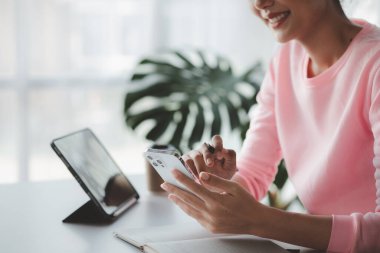 İşe ara verdiğinde cep telefonuyla oynayan güzel bir Asyalı kadın. Yeni başlayan bir şirketin pazarlama müdürü, kadın lider, yönetici ve CEO 'su. Kadın Liderlik Konsepti.