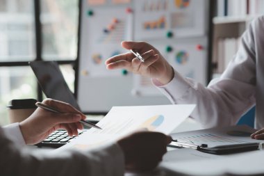 İki işadamı toplantı materyaline işaret ederek, ortak iş sorunlarını geliştirme ve çözme planında birlikte çalıştılar. Büyüme ve kalite için işletme yönetimi kavramı.