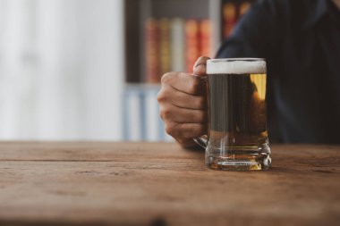 Elinde bir bardak brendi tutan bir adam, bir barda brendi içiyor, alkol içiyor araba kullanma yeteneğine zarar veriyor ve sağlığa zarar verebilir. Alkol konsepti.