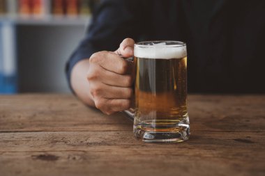 Elinde bir bardak brendi tutan bir adam, bir barda brendi içiyor, alkol içiyor araba kullanma yeteneğine zarar veriyor ve sağlığa zarar verebilir. Alkol konsepti.