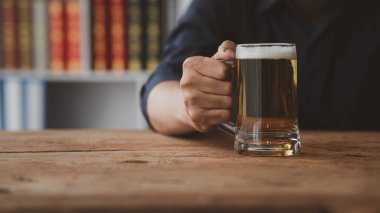 Elinde bir bardak brendi tutan bir adam, bir barda brendi içiyor, alkol içiyor araba kullanma yeteneğine zarar veriyor ve sağlığa zarar verebilir. Alkol konsepti.