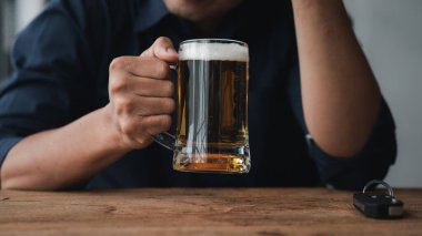 Elinde bir bardak brendi tutan bir adam, bir barda brendi içiyor, alkol içiyor araba kullanma yeteneğine zarar veriyor ve sağlığa zarar verebilir. Alkol konsepti.