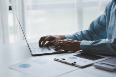 Bir iş adamı şirketin mali belgelerini kontrol ediyor ve bir mesajlaşma programı aracılığıyla finans müdürüyle konuşmak için dizüstü bilgisayar kullanıyor. Şirket mali yönetimi kavramı.