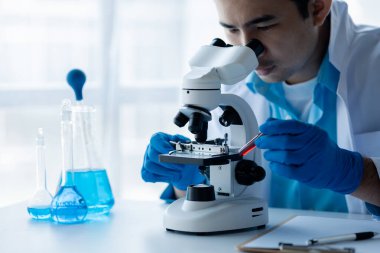 Laboratuvar asistanı, tıp bilimcisi, kimya araştırmacısı kan örneğinde cam bir tüp tutuyor, kimyasal bir deney yapıyor ve hastanın kan örneğini inceliyor. Tıp ve araştırma konsepti.