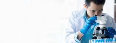 Laboratuvar asistanı, tıp bilimcisi, kimya araştırmacısı kan örneğinde cam bir tüp tutuyor, kimyasal bir deney yapıyor ve hastanın kan örneğini inceliyor. Tıp ve araştırma konsepti.