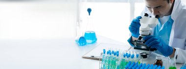 Laboratuvar asistanı, tıp bilimcisi, kimya araştırmacısı kan örneğinde cam bir tüp tutuyor, kimyasal bir deney yapıyor ve hastanın kan örneğini inceliyor. Tıp ve araştırma konsepti.