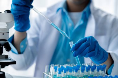 Laboratuvar asistanı, tıp bilimcisi, kimya araştırmacısı kan örneğinde cam bir tüp tutuyor, kimyasal bir deney yapıyor ve hastanın kan örneğini inceliyor. Tıp ve araştırma konsepti.