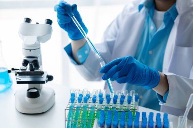 Laboratuvar asistanı, tıp bilimcisi, kimya araştırmacısı kan örneğinde cam bir tüp tutuyor, kimyasal bir deney yapıyor ve hastanın kan örneğini inceliyor. Tıp ve araştırma konsepti.