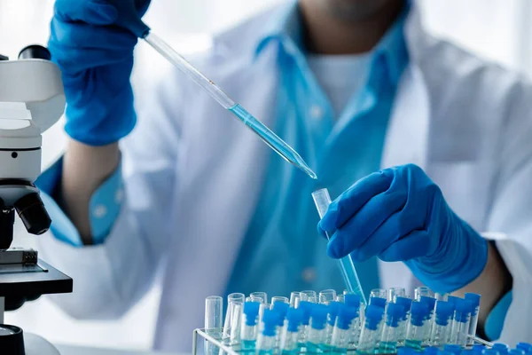 Laboratuvar asistanı, tıp bilimcisi, kimya araştırmacısı kan örneğinde cam bir tüp tutuyor, kimyasal bir deney yapıyor ve hastanın kan örneğini inceliyor. Tıp ve araştırma konsepti.