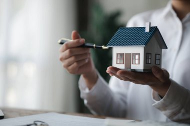 Ev satış temsilcileri ve satış temsilcileri projedeki evleri görmek isteyen müşterilere projede konut detaylarını tavsiye ediyorlar. Gayrimenkul ticareti.