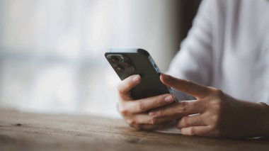 Business man looking at financial information from a mobile phone, he is checking company financial documents, he is an executive of a startup company. Concept of financial management.