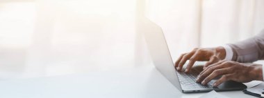 Laptop klavyesinde yazan kişi, dizüstü bilgisayarda çalışan iş adamı, iş arkadaşlarına mesaj yazıyor ve toplantıyı özetlemek için mali bilgi tablosu hazırlıyor..