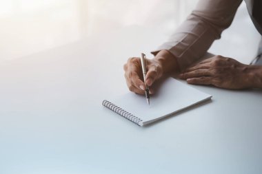 Bir iş kadını not defterine notlar alıyor, şirketin mali belgelerini kontrol ediyor ve düzeltilmesi için maliye müdürüne düzeltici raporlar götürüyor. Finans kavramı.