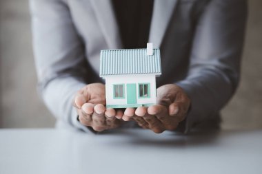 Ev satış temsilcileri ve satış temsilcileri projedeki evleri görmek isteyen müşterilere projede konut detaylarını tavsiye ediyorlar. Gayrimenkul ticareti.