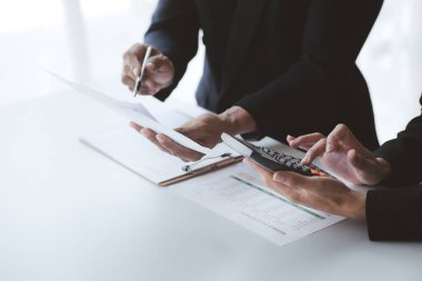 İki işadamı toplantı materyaline işaret ederek, ortak iş sorunlarını geliştirme ve çözme planında birlikte çalıştılar. Büyüme ve kalite için işletme yönetimi kavramı.