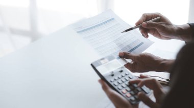 İki işadamı toplantı materyaline işaret ederek, ortak iş sorunlarını geliştirme ve çözme planında birlikte çalıştılar. Büyüme ve kalite için işletme yönetimi kavramı.