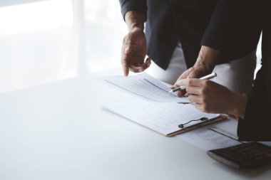 İki işadamı toplantı materyaline işaret ederek, ortak iş sorunlarını geliştirme ve çözme planında birlikte çalıştılar. Büyüme ve kalite için işletme yönetimi kavramı.