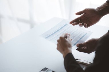 İki işadamı toplantı materyaline işaret ederek, ortak iş sorunlarını geliştirme ve çözme planında birlikte çalıştılar. Büyüme ve kalite için işletme yönetimi kavramı.