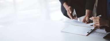 İki işadamı toplantı materyaline işaret ederek, ortak iş sorunlarını geliştirme ve çözme planında birlikte çalıştılar. Büyüme ve kalite için işletme yönetimi kavramı.