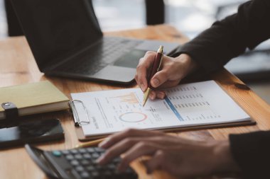 İşadamı, şirketin mali bilgilerini gösteren bir pasta grafiğine işaret ederek şirketin mali bilgilerini harita halinde gösteren özel ofisinde oturuyor. Finansal kavramlar