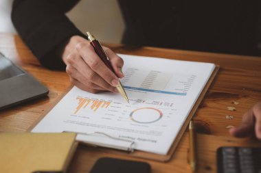 İşadamı, şirketin mali bilgilerini gösteren bir pasta grafiğine işaret ederek şirketin mali bilgilerini harita halinde gösteren özel ofisinde oturuyor. Finansal kavramlar