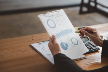 İşadamı, şirketin mali bilgilerini gösteren bir pasta grafiğine işaret ederek şirketin mali bilgilerini harita halinde gösteren özel ofisinde oturuyor. Finansal kavramlar