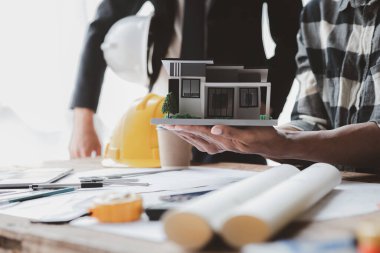 Architects and engineers are working together to edit the draft house plan that was designed after it was presented to the client and partially revised the design. Interior design and decoration ideas