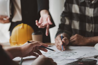 Architects and engineers are working together to edit the draft house plan that was designed after it was presented to the client and partially revised the design. Interior design and decoration ideas