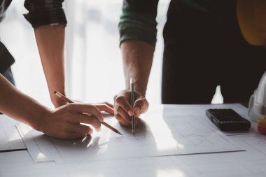 Architects and engineers are working together to edit the draft house plan that was designed after it was presented to the client and partially revised the design. Interior design and decoration ideas