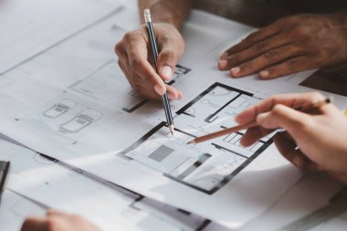 Architects and engineers are working together to edit the draft house plan that was designed after it was presented to the client and partially revised the design. Interior design and decoration ideas
